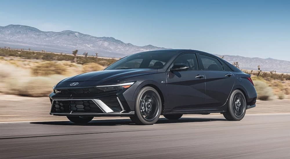 A gray 2026 Hyundai Elantra driving on a sunny day.