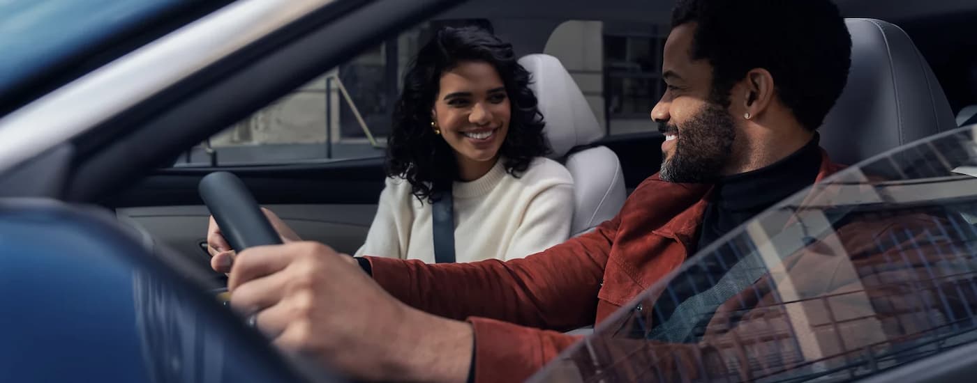 Two people driving in a 2026 Hyundai Tuscon