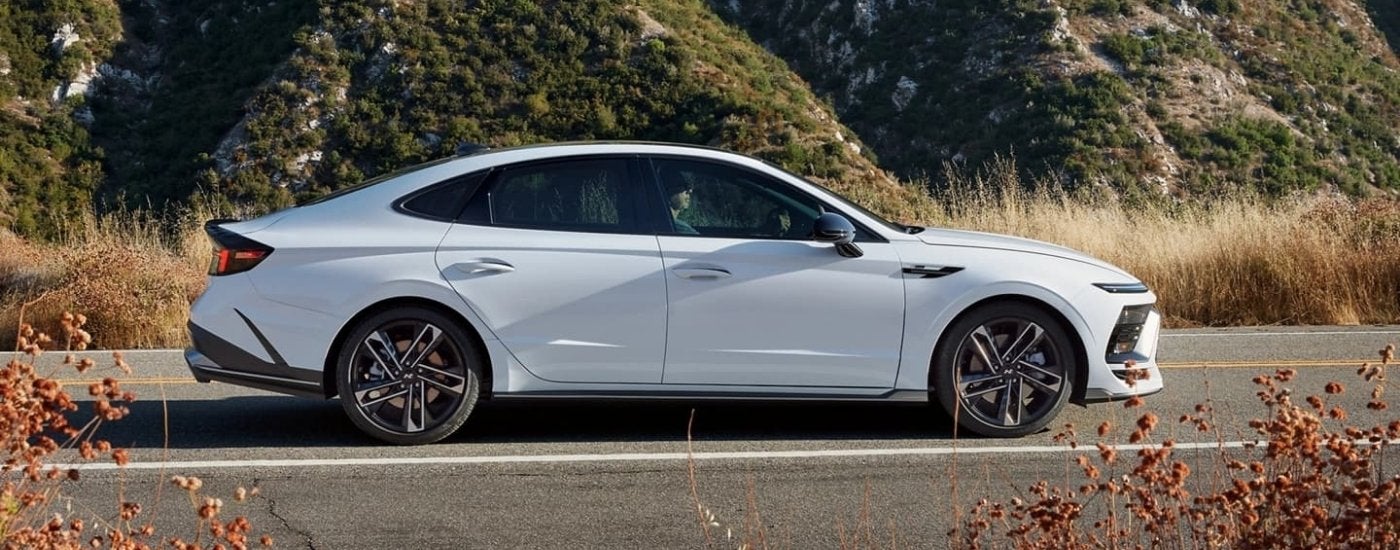 White 2024 Hyundai Sonata N-Line driving to a Hyundai dealer