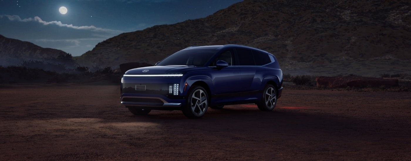 Blue 2026 Hyundai IONIQ 9 parked off-road at night