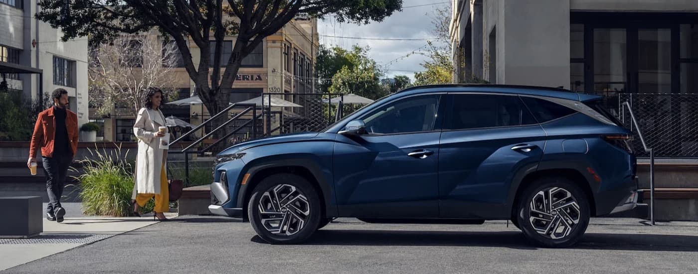 A blue 2025 Hyundai Tucson parked in a city.